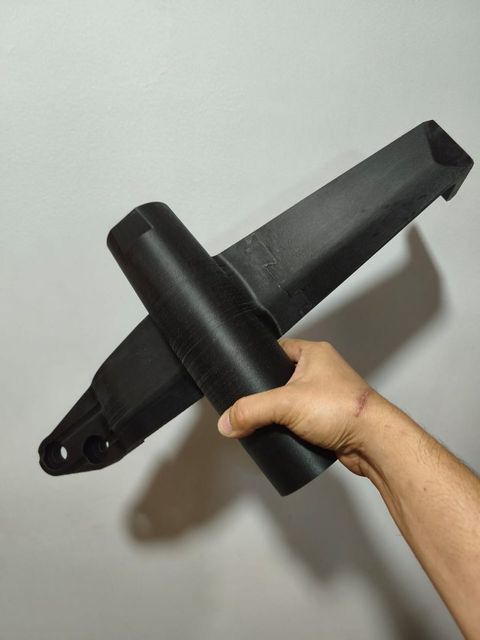 Brazo estructural completo impreso por Proinn, sostenido en la mano para dar escala