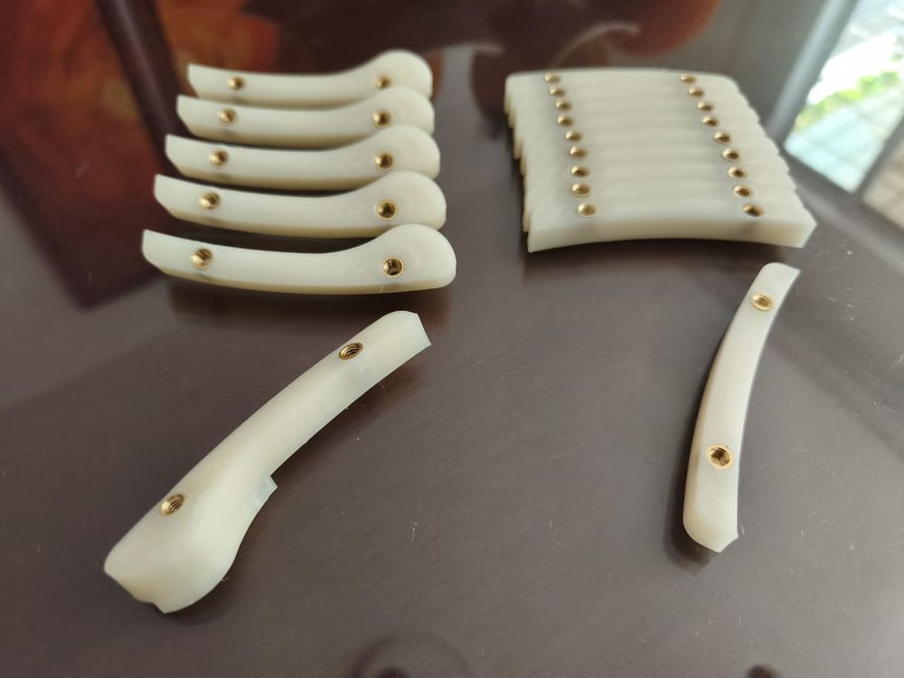 Piezas curvas en polímero blanco con insertos roscados de latón
