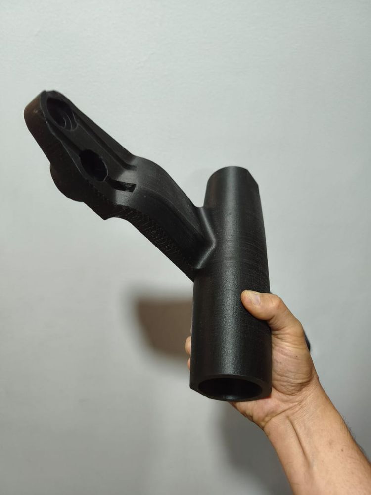 Pieza negra grande en forma de Y sostenida en la mano, que da la escala