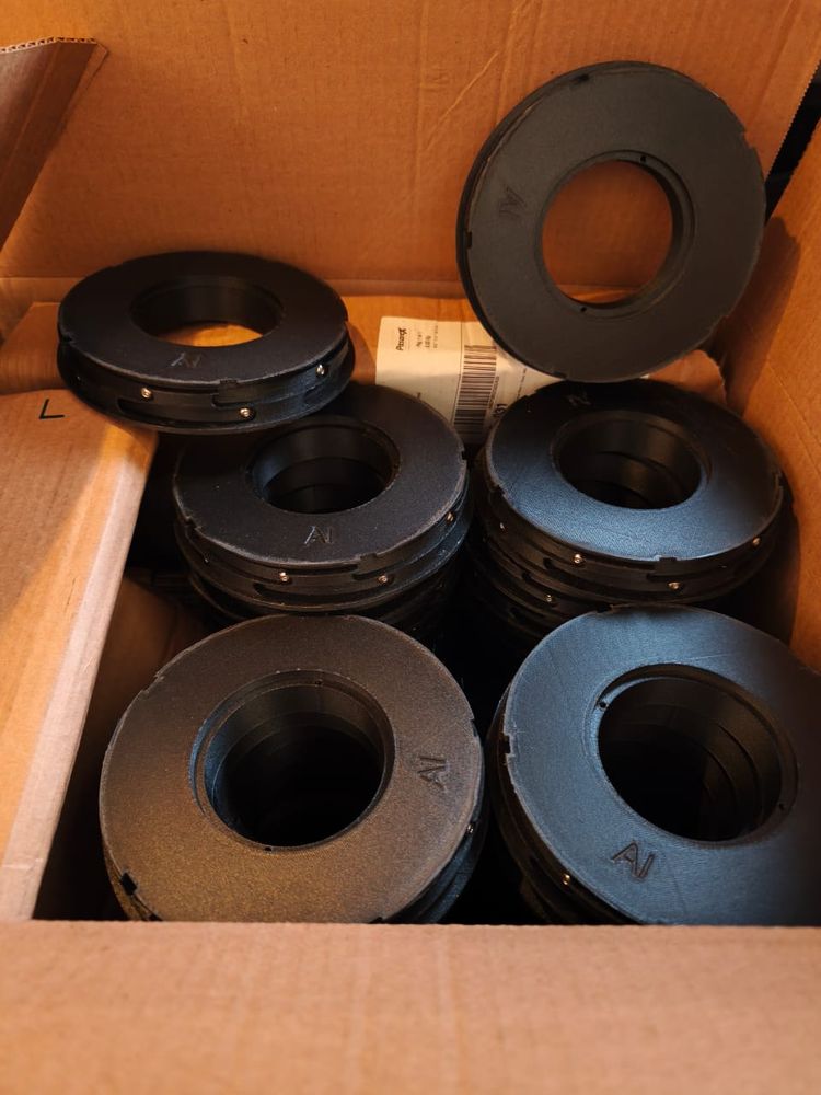Caja de cartón con piezas redondas negras marcadas, listas para entregar